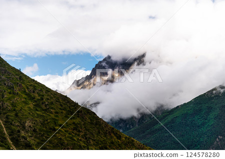 Picturesque mountain landscape. View of the mountain in the snow, covered with fog. Colorful travel background Picturesque mountain landscape. View of the mountain in the snow, covered with fog. Colorful travel background 124578280