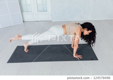 woman doing asana gymnastics on the floor in the hall 124578490
