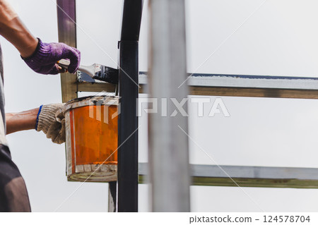 Man painting anti rust paint on steel at home decorated. 124578704