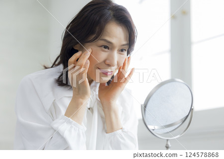 A middle woman watching a mirror 124578868