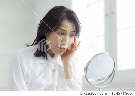 A middle woman watching a mirror A middle woman watching a mirror 124578869
