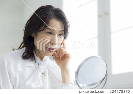A middle woman watching a mirror 124578870