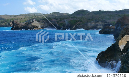 Turquoise ocean sea water white wave splashing deep blue sea. Bird eye view monster wave splash on rock. Tropical sea beach in summer seaside outdoor. Ocean island beautiful dramatic landscape. Turquoise ocean sea water white wave splashing deep blue sea. Bird eye view monster wave splash on rock. Tropical sea beach in summer seaside outdoor. Ocean island beautiful dramatic landscape. 124579518