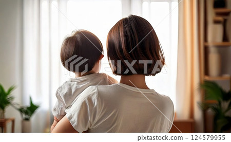 Back view of a woman holding a child in her arms 124579955