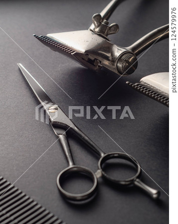 Two types of barber tools are displayed on a polished black surface, highlighting their design and functionality. 124579976