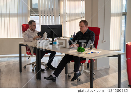Two Caucasian men working in an office.  124580385