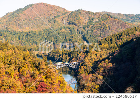 Fukushima, JAPAN - Nov 10, 2024: Train run cross Daichi Tagamigawa Bridge view from First Tadami River Bridge 124580517