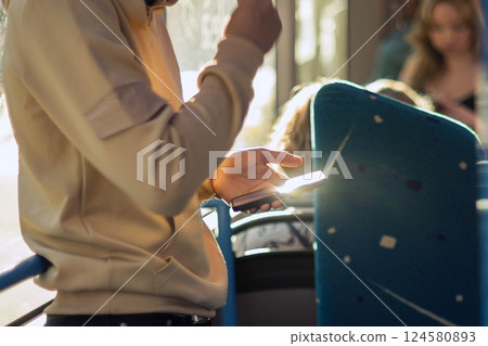 man using a smart phone in a public transport 124580893