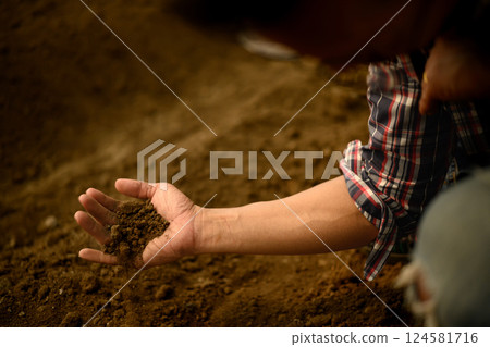 Close up of an agronomist analyzing soil quality for crop cultivation 124581716