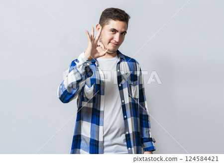 Handsome guy gesturing everything is ok, Person making ok gesture isolated, Smiling man showing ok gesture looking at camera, Concept of expression of everything is fine. Handsome guy gesturing everything is ok, Person making ok gesture isolated, Smiling man showing ok gesture looking at camera, Concept of expression of everything is fine. 124584421