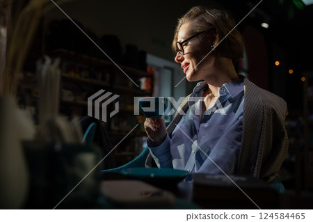 Woman in suit with books reading in restaurant 124584465