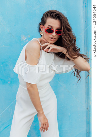 Beautiful Slim Fashion Woman in White Suit on Blue Background Beautiful Slim Fashion Woman in White Suit on Blue Background 124584544