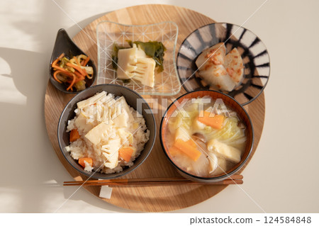 A Japanese set meal with rice cooked with bamboo shoots, miso soup with lots of ingredients, and small dishes such as boiled young bamboo shoots. Japanese home cooking 124584848