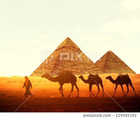 Horizontal banner with caravan of camels and Great Pyramids of Chephren and Cheops, Cairo, Egypt. Man with three dromedary in two pyramids, Giza complex (Giza Necropolis). On sunrise sky background Horizontal banner with caravan of camels and Great Pyramids of Chephren and Cheops, Cairo, Egypt. Man with three dromedary in two pyramids, Giza complex (Giza Necropolis). On sunrise sky background 124585102