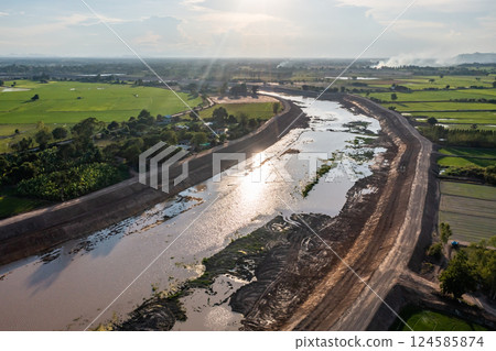Construction dredges up for a canal and dam, to prevent a flood in the rainy season. Date on 14 May 2021 at Uthai Thani province, Thailand. 124585874