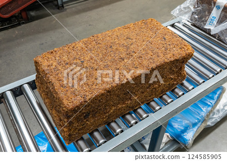 The natural rubber bales products on the industrial automatic conveyor belt machine in a rubber factory. The natural rubber bales products on the industrial automatic conveyor belt machine in a rubber factory. 124585905