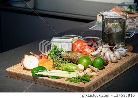 Ingredients of TomYamKung (Shrimp Spicy Thai Soup) is a lemon, prawn, chilli, lemon grass, onion, tomato, mushroom and condiment sauce on the kitchen counter. 124585910