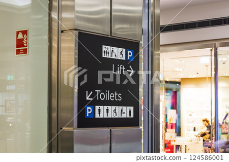 Modern shopping center sign showing directions for lift, restrooms, and parking 124586001