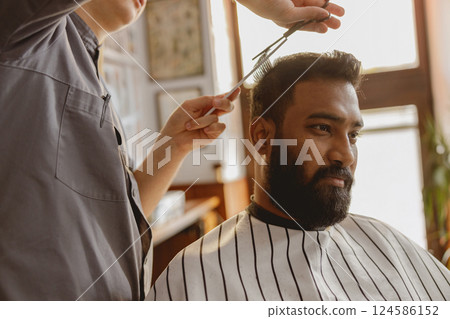 A Skilled Barber is Expertly Styling a Clients Hair in a Trendy and Modern Barbershop 124586152