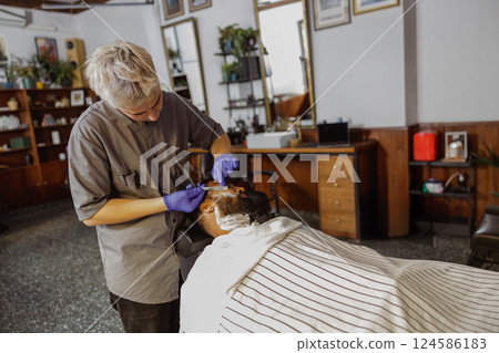 A skilled aesthetician offers a luxurious, rejuvenating facial treatment in a modern spa 124586183