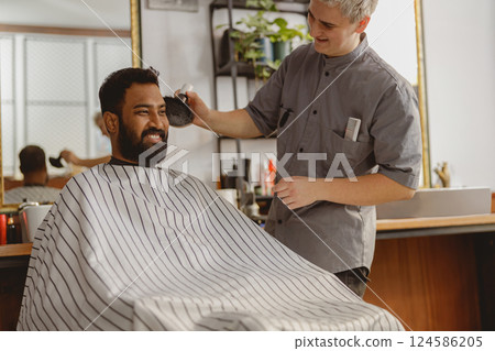A Skilled Barber is Providing a Fresh and Stylish Haircut to a Client in a Trendy Salon Setting 124586205