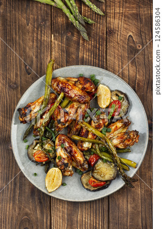 Baked chicken wings with vegetables. Baked chicken wings with vegetables. 124586304