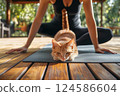 Cat lies on yoga mat near female owner practicing yoga wooden terrace. AI-generated item 124586604