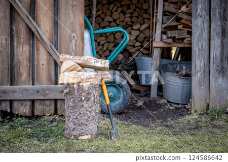 Wood Chopping Tools and Stacked Firewood in Outdoor Shed Wood Chopping Tools and Stacked Firewood in Outdoor Shed 124586642