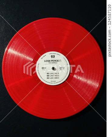 Vibrant red vinyl record on black background for music enthusiasts and retro decor 124587110