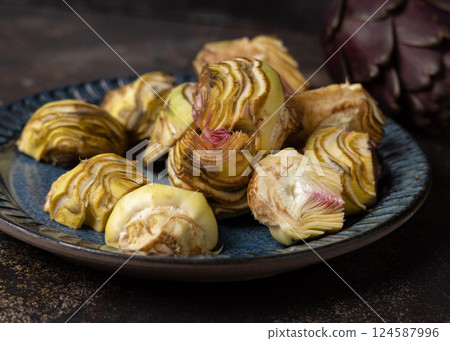 Plate full of fresh raw artichoke hearts ready to cook closeup. Italian cousine ingredient Plate full of fresh raw artichoke hearts ready to cook closeup. Italian cousine ingredient 124587996