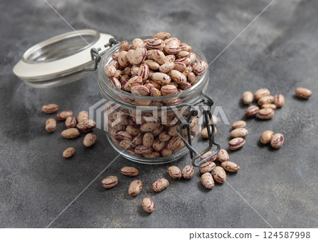 Glass jar full of dried pinto beans on gray closeup, copy space. Traditional Latin American legumes Glass jar full of dried pinto beans on gray closeup, copy space. Traditional Latin American legumes 124587998