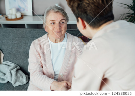No face caregiver warmly holding hands of senior woman. Elderly parents, grandparents care, support. Family enjoying tender moment together at care home, generations relations concept. Age caregiving. No face caregiver warmly holding hands of senior woman. Elderly parents, grandparents care, support. Family enjoying tender moment together at care home, generations relations concept. Age caregiving. 124588035