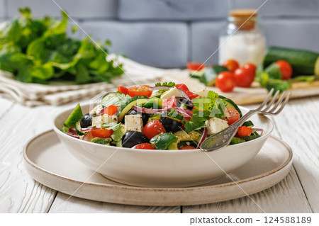 greek salad of veggies, olives, cheese in bowl 124588189