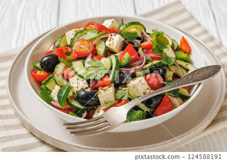 greek salad of veggies, olives, cheese in bowl 124588191
