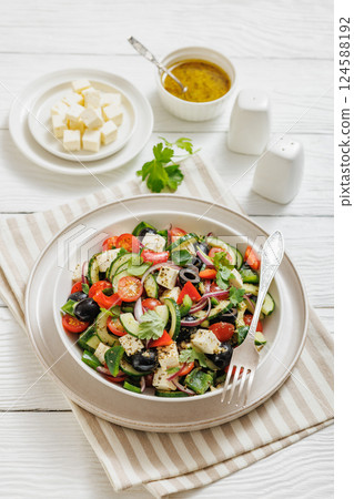 greek salad of veggies, olives, cheese in bowl 124588192