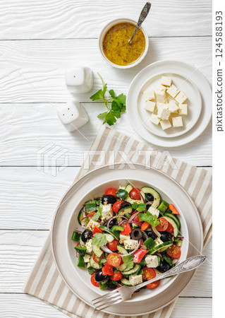 greek salad of veggies, olives, cheese in bowl 124588193
