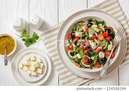 greek salad of veggies, olives, cheese in bowl 124588194