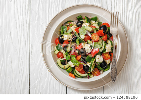 greek salad of veggies, olives, cheese in bowl 124588196
