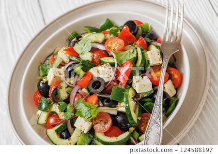 greek salad of veggies, olives, cheese in bowl 124588197