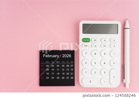 February 2026 calendar and white calculator with pen on pink background. 124588246