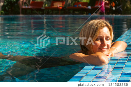 Young smiling woman in swimming pool. Happy blonde in tropical resort pool. Tan blonde in pool. Summertime fun. Active lifestyle. Chill in wellness spa. Summer enjoy. Young smiling woman in swimming pool. Happy blonde in tropical resort pool. Tan blonde in pool. Summertime fun. Active lifestyle. Chill in wellness spa. Summer enjoy. 124588286