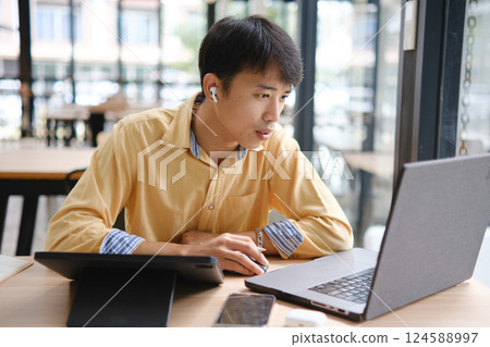 Student studying online and preparing for exams with digital devices and books 124588997