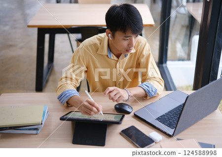 Student studying online and preparing for exams with digital devices and books 124588998