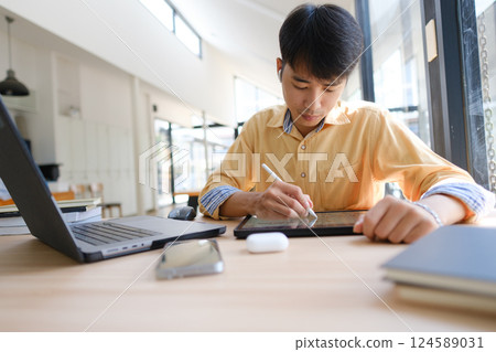Student studying online and preparing for exams with digital devices and books 124589031