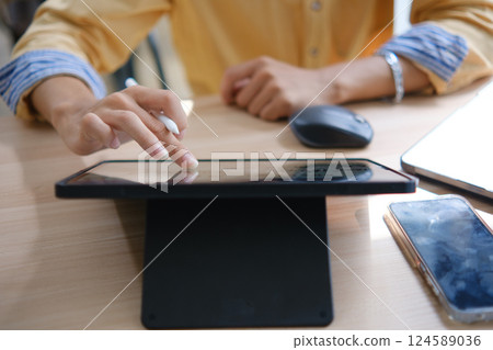 Male web designer drawing with graphic tablet at table in office. Male web designer drawing with graphic tablet at table in office. 124589036