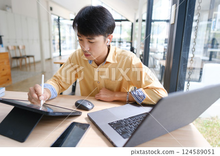 Student studying online and preparing for exams with digital devices and books 124589051
