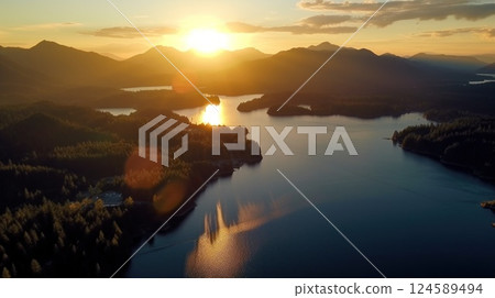 Sunset illuminates a winding river in a valley between tree covered mountains, creating a stunning landscape 124589494