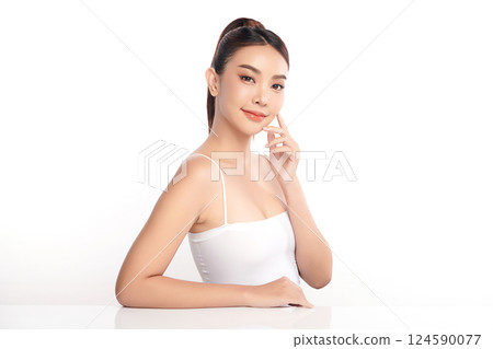 A beautiful young Asian woman with clean, fresh skin against a white background. Skincare, facial treatment, cosmetology, beauty, and spa. An elegant portrait of an Asian woman. 124590077
