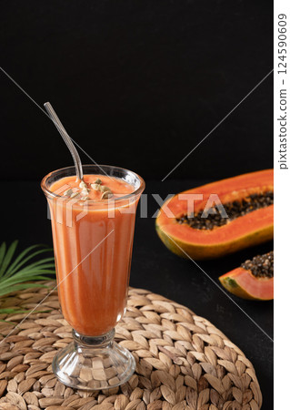 Papaya lassi in glass on black background. 124590609