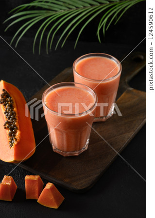 Papaya lassi in glass on black background. 124590612